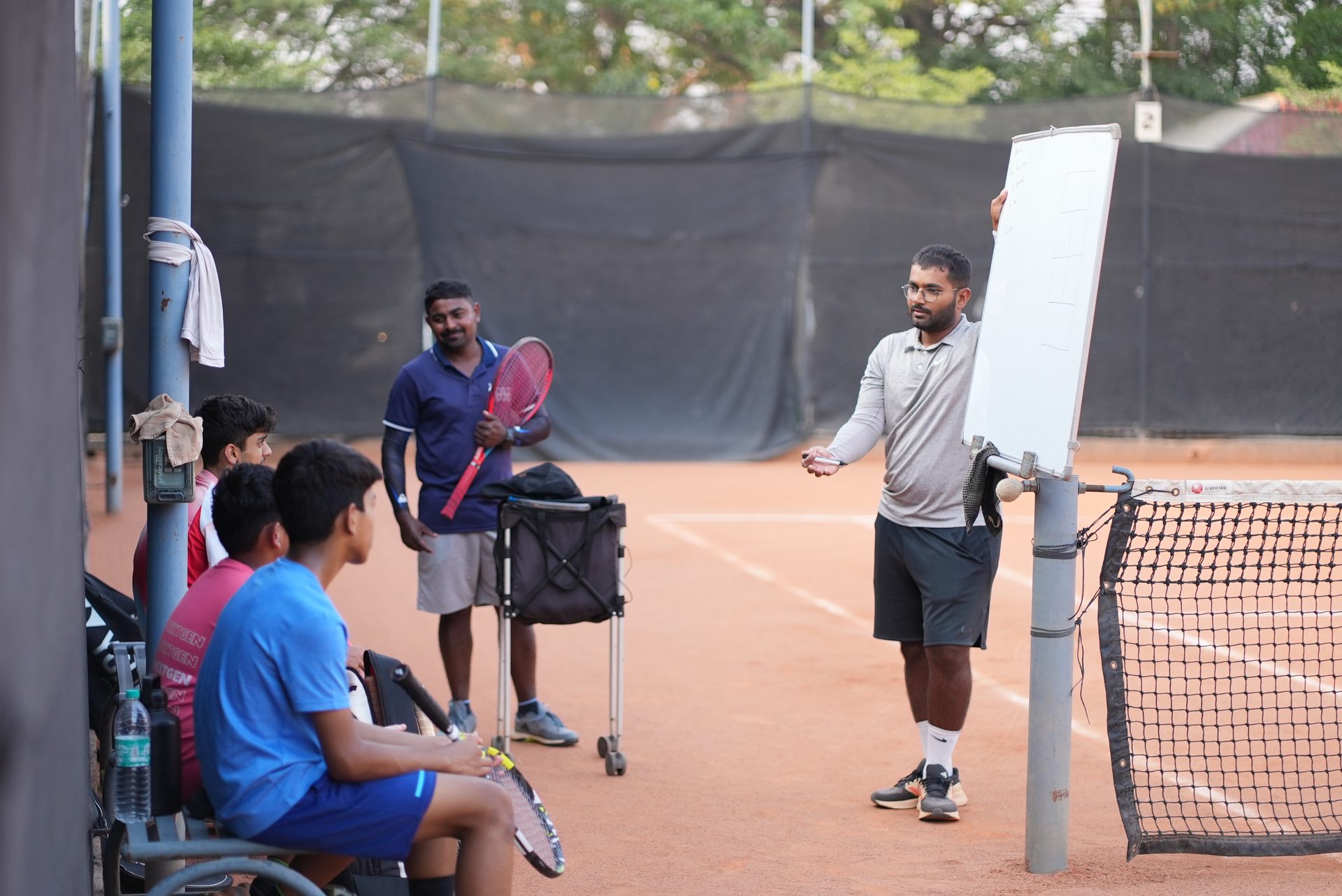 Coach reviewing a session plan with players courtside