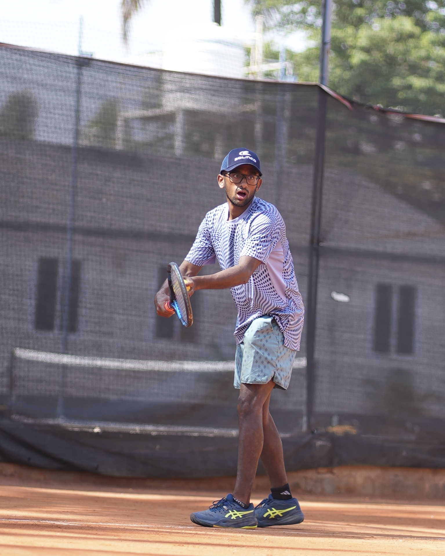 Performance player mid-shot on the clay court